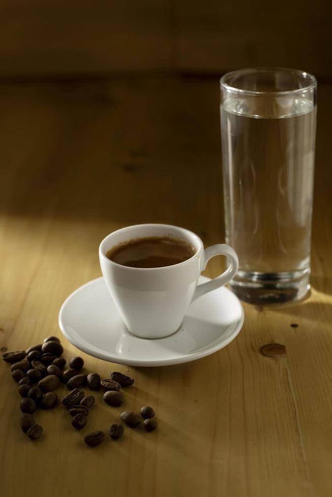 taza de café y frijoles en la mesa de madera foto