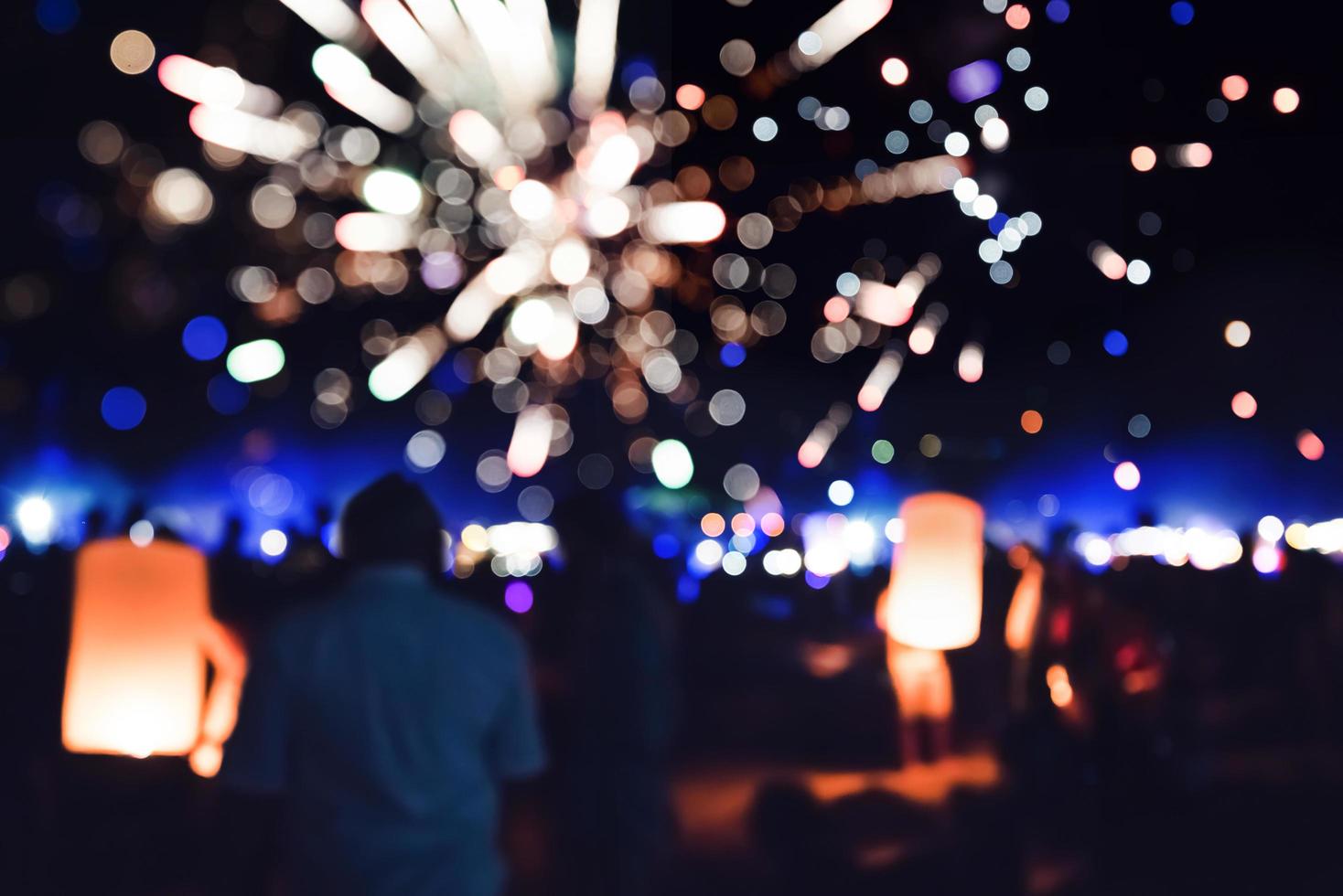 la gente celebra el año nuevo. Desenfoque de círculo de fuegos artificiales. colorido en celebración. playa de tailandia foto