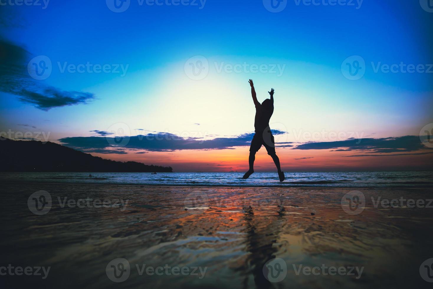 hombre asiático divertido saltando y feliz con el turismo de playa. verano foto