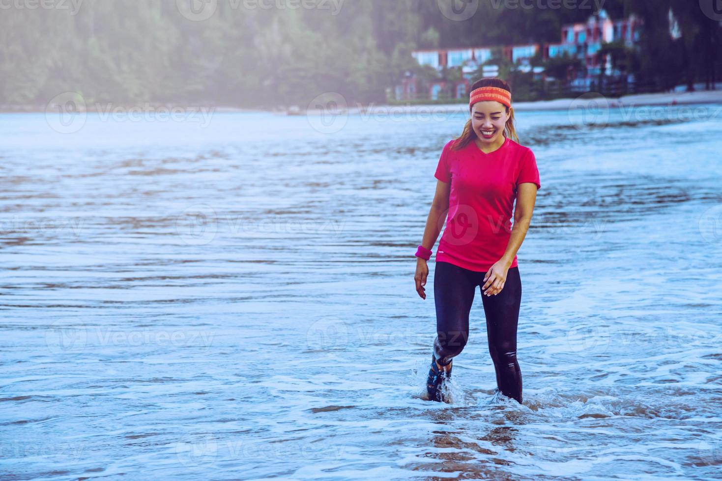 Woman jogging workout on the beach in the morning. Relax with the sea walk. in summer photo