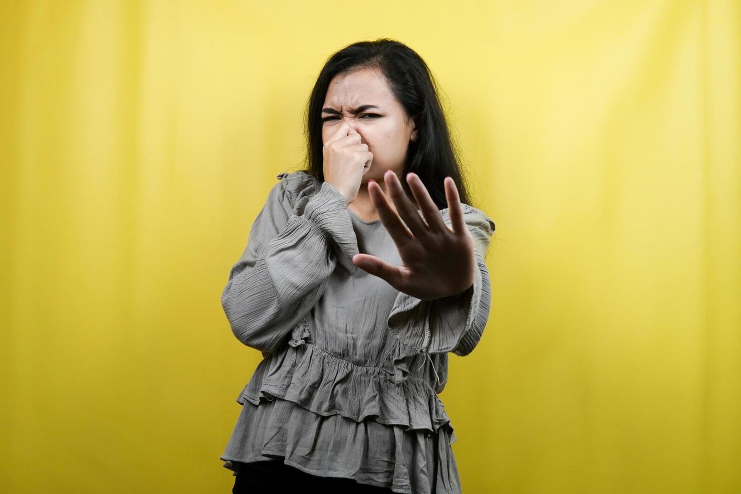 Beautiful young woman with hand covering mouth, refusing something isolated photo