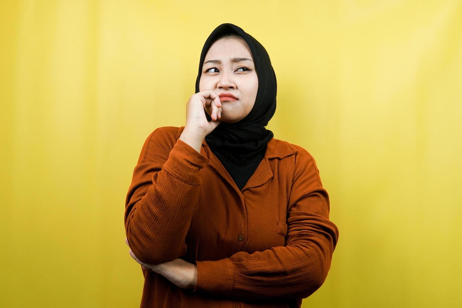 Beautiful asian young muslim woman thinking, looking for ideas, looking for solutions to problems, with hands holding chin, isolated photo