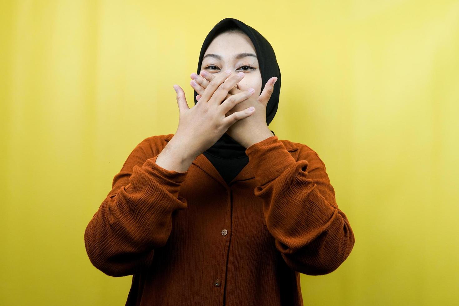 Beautiful young asian muslim woman shocked, surprised, disbelieving, getting shocking information, with hands covering mouth isolated photo