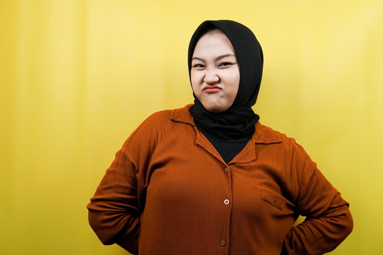 Beautiful young asian muslim woman pouting, belittling, disappointed, dissatisfied, not good, bad job, lousy, weak, looking at camera isolated photo