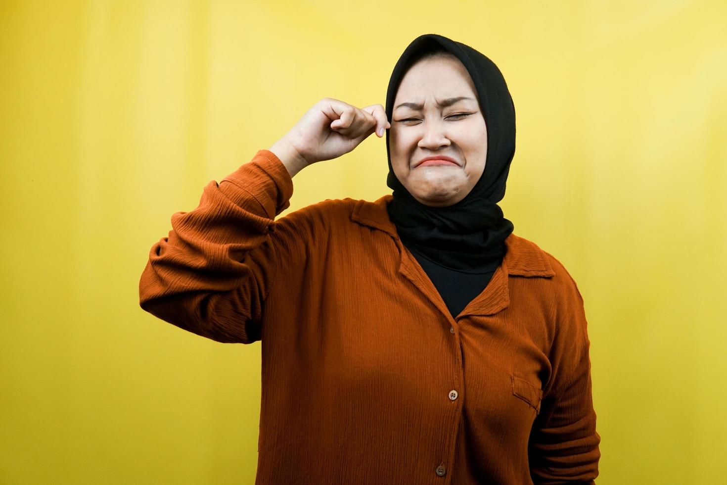 Beautiful young muslim woman crying, hands wiping tears, isolated photo