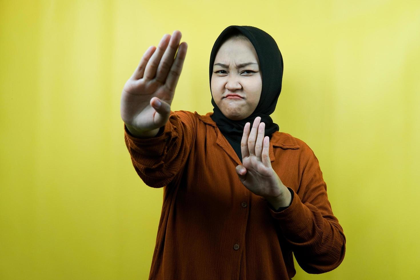 Hermosa joven musulmana asiática con la mano de la señal de pare, rechazar la mano de la señal, la mano de la señal de prohibición, no acercarse a la mano, mantenerse alejado de la mano de la señal, no mover la mano de la señal, aislado foto