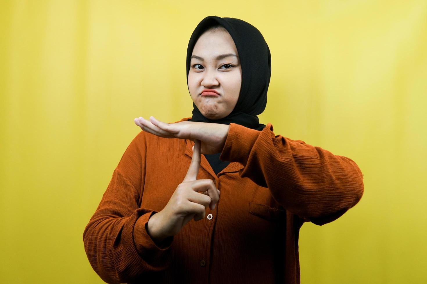 Beautiful asian young muslim woman with hand showing stop sign, silent sign hand, do not speak sign hand, do not make noise sign hand, isolated photo