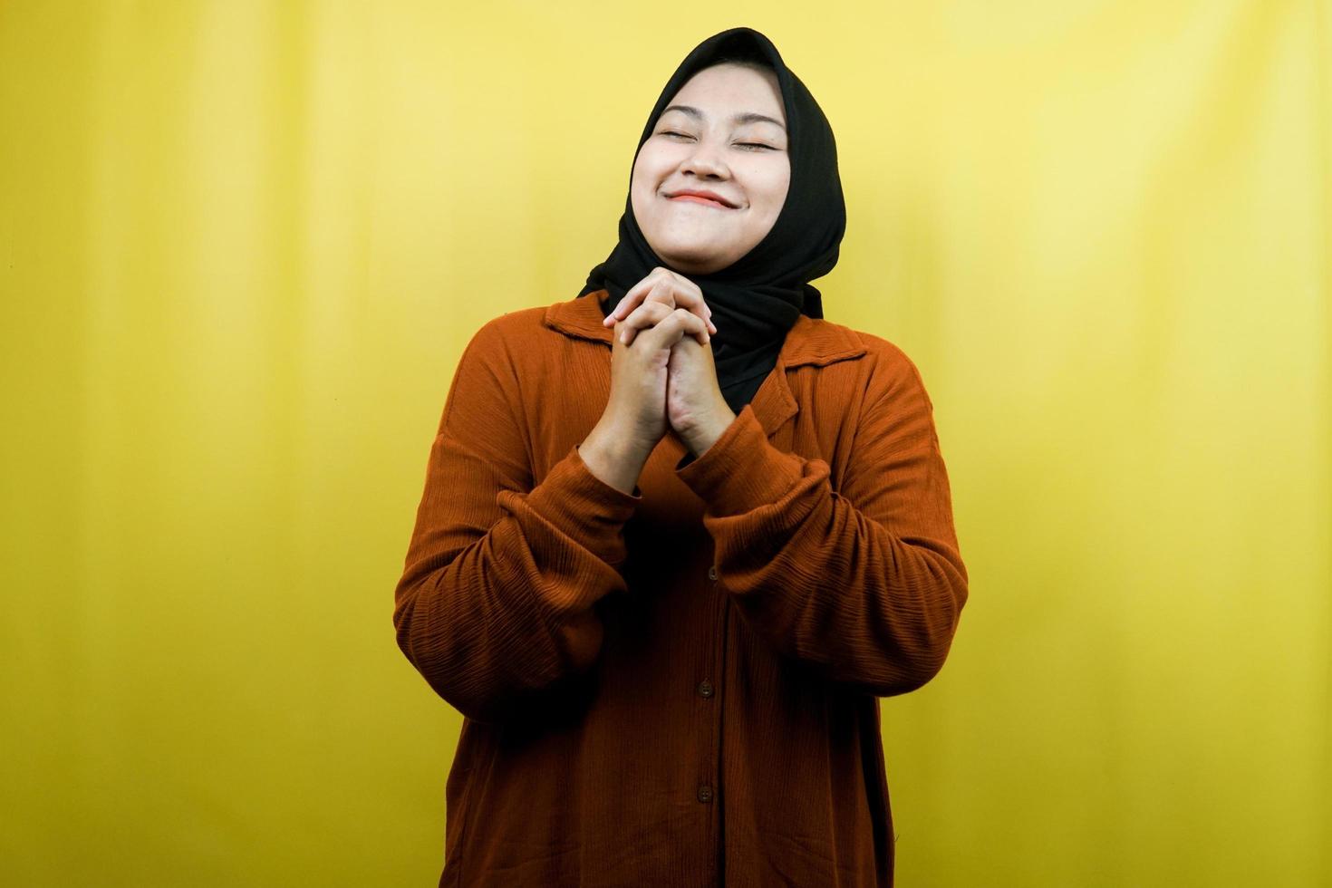 Beautiful and cheerful young asian muslim woman, hands on face, isolated photo