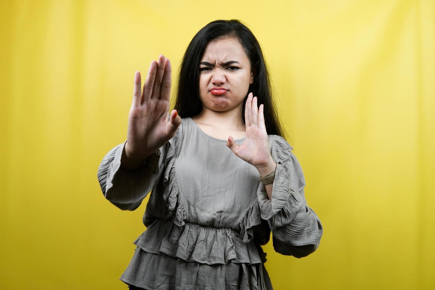 Beautiful young woman serious, with stop sign hand, prohibition sign hand, rejection, advertisement, isolated photo