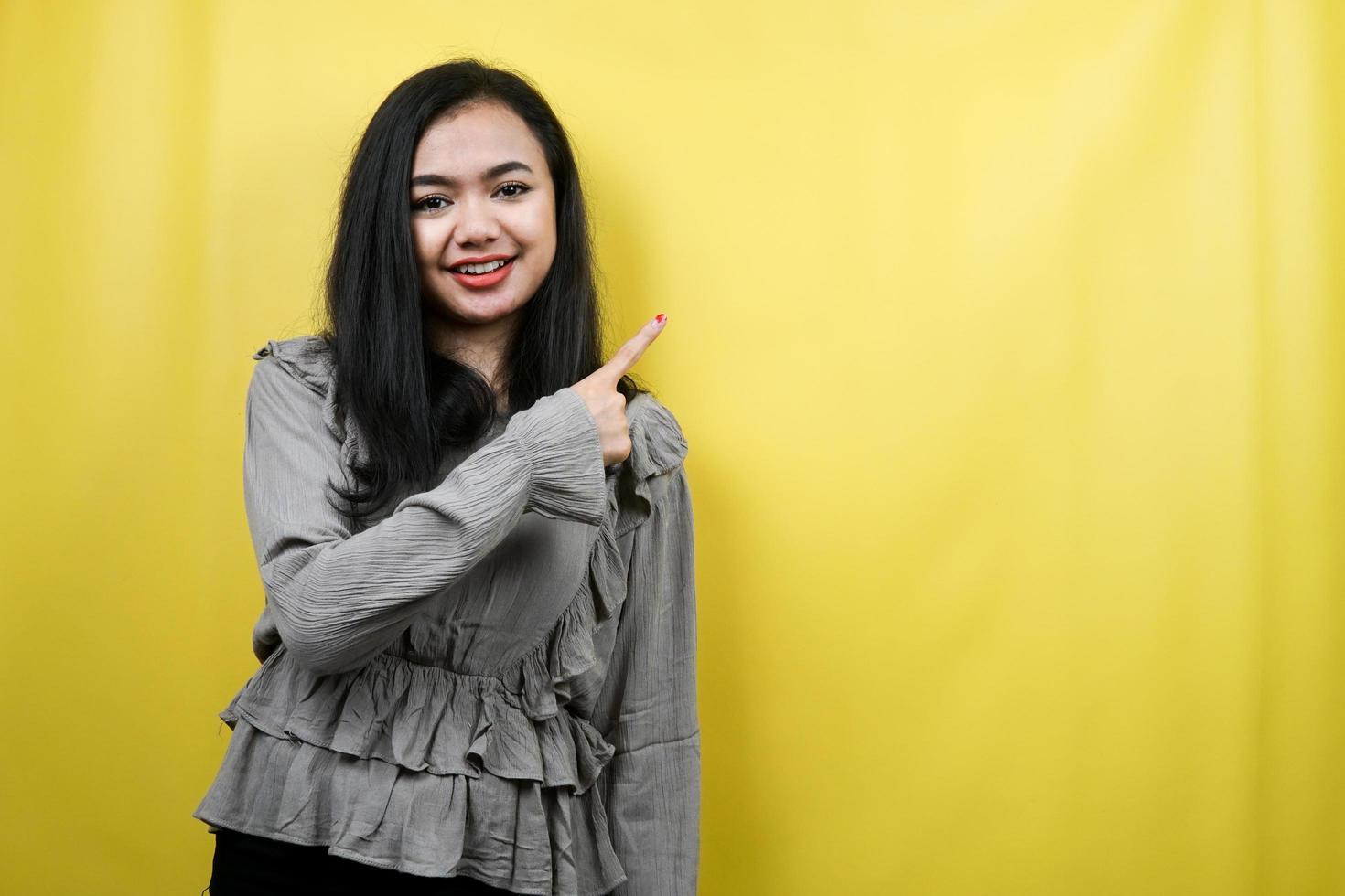 Hermosa joven manos apuntando al espacio vacío presentando algo, promocionando productos, alegre y confiado, publicidad, aislado foto