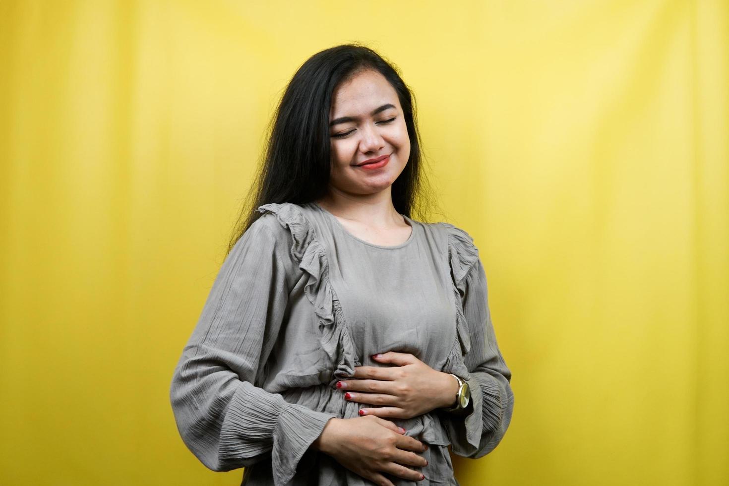 hermosa mujer joven alegre, feliz, con las manos sosteniendo el vientre, vientre lleno, publicidad, aislado foto