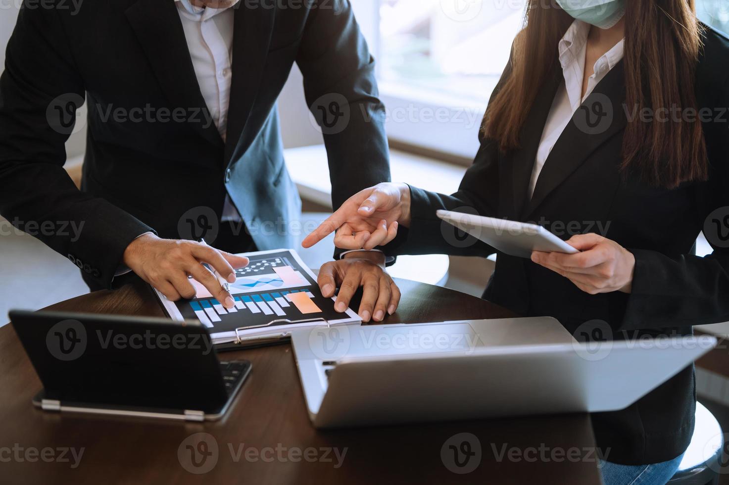 two colleagues discussing data on desk as concept in morning light. photo