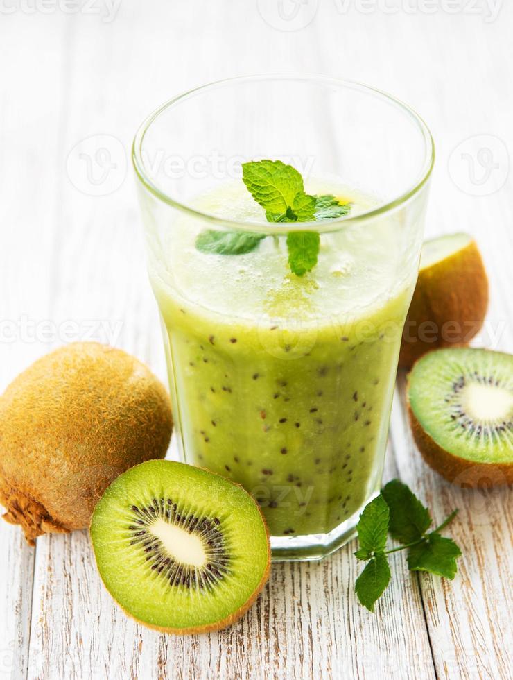 Vaso de batido de kiwi con frutas frescas foto