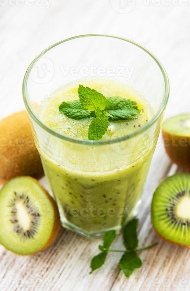 Vaso de batido de kiwi con frutas frescas foto