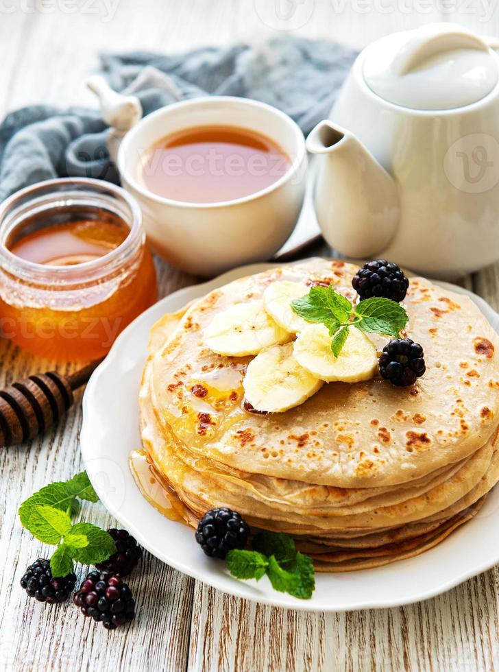 Delicious pancakes with blackberries and bananas photo