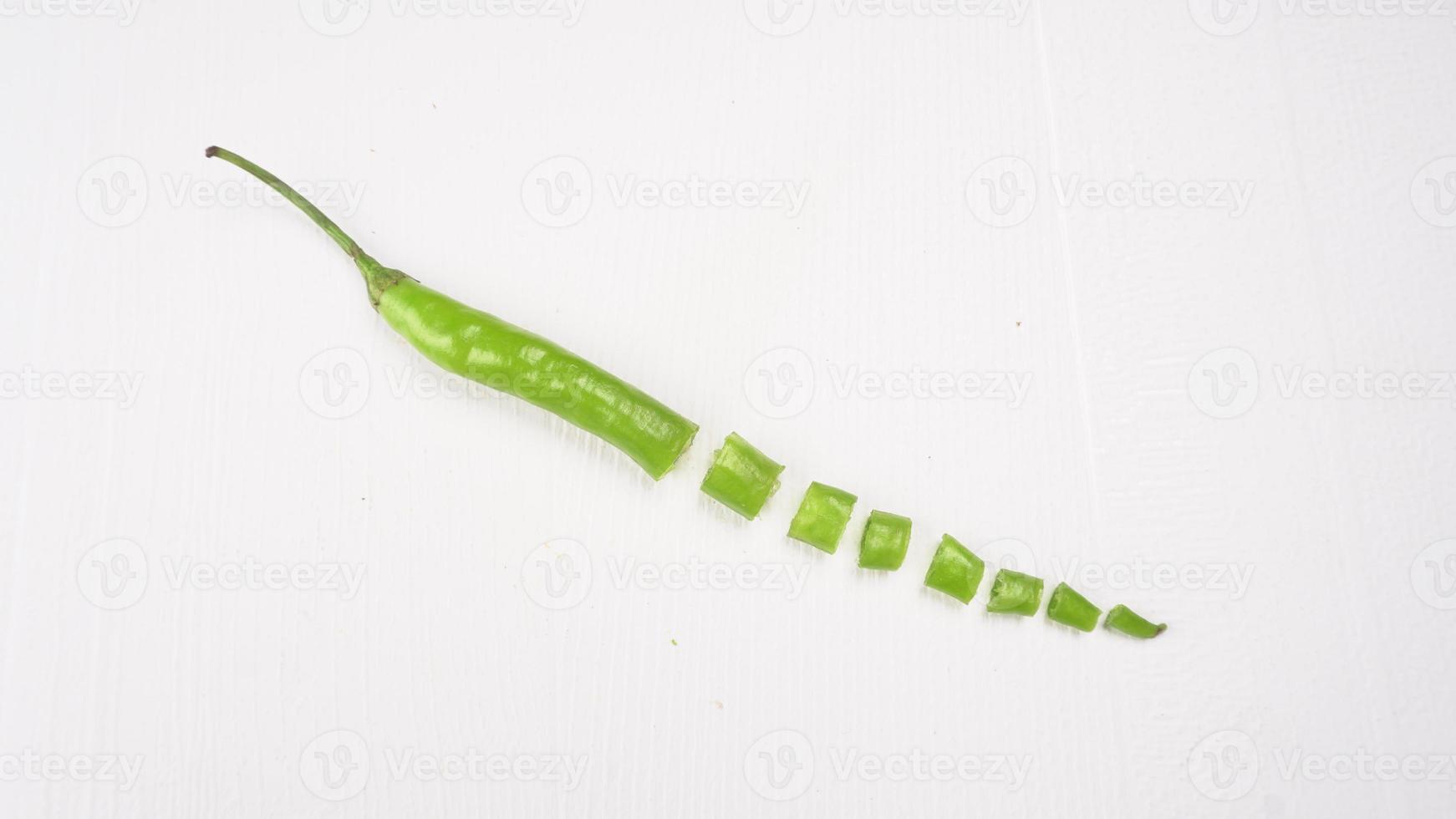 Fresh long Indian green chillies on wooden background. photo