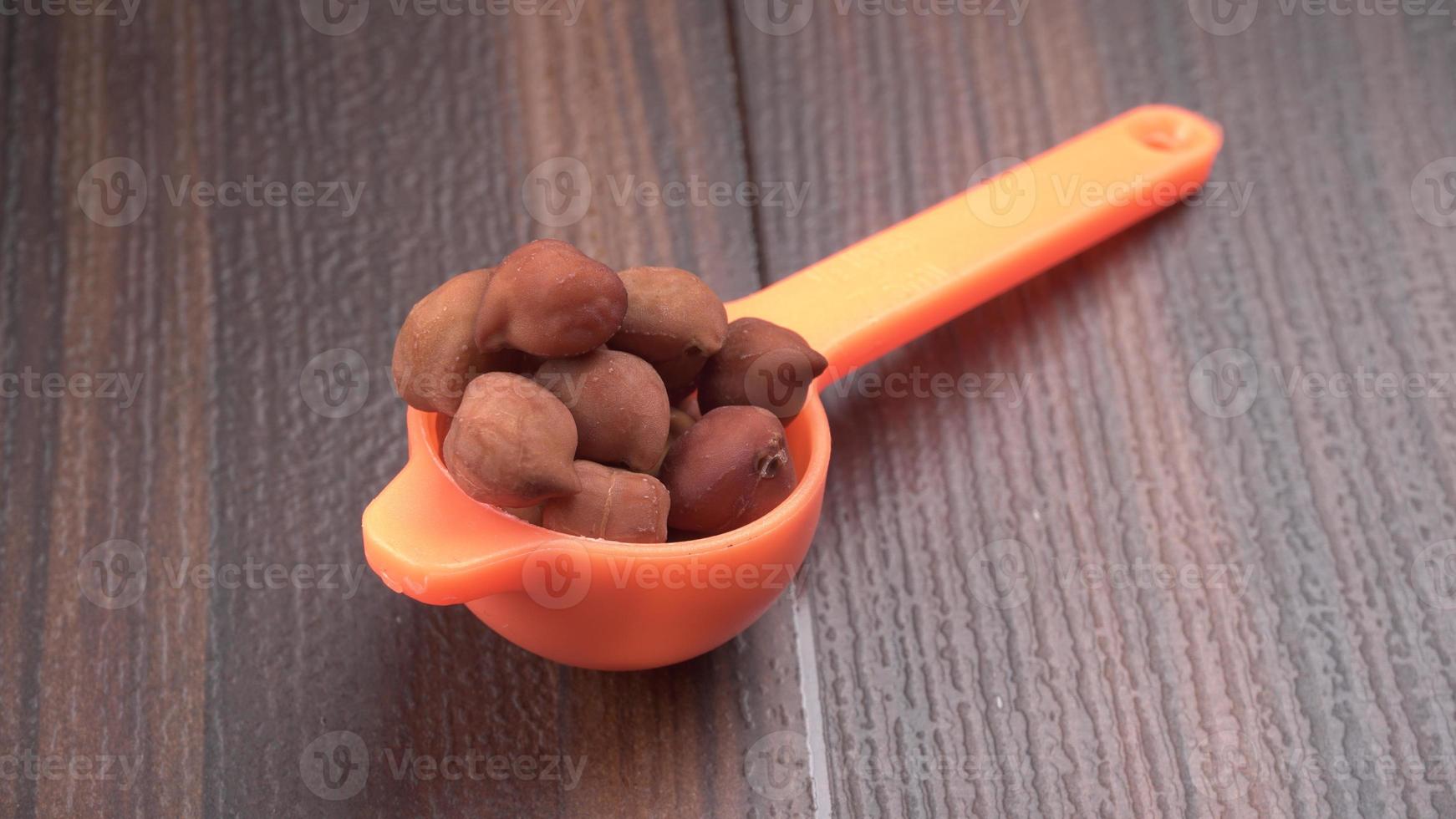 Black Chickpeas or Kala Chana with chana dal pulse isolated on wooden Background. photo