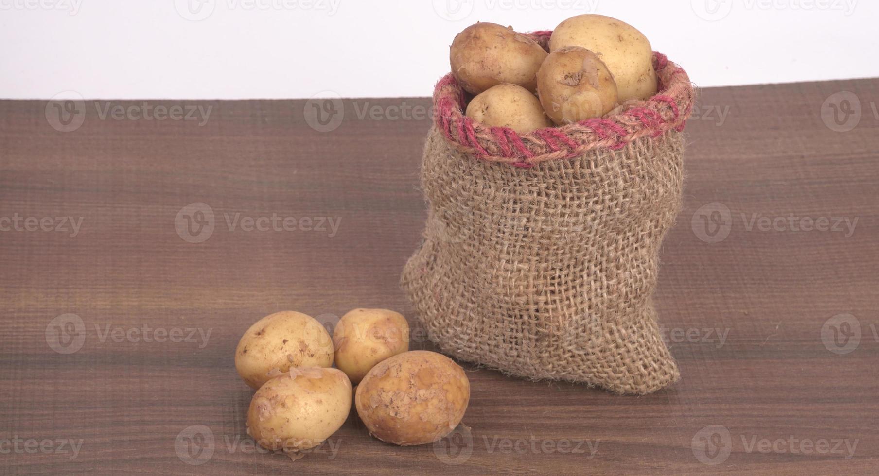 Fresh small potatoes for cooking in a wooden bowl. With copy space  on white background. photo