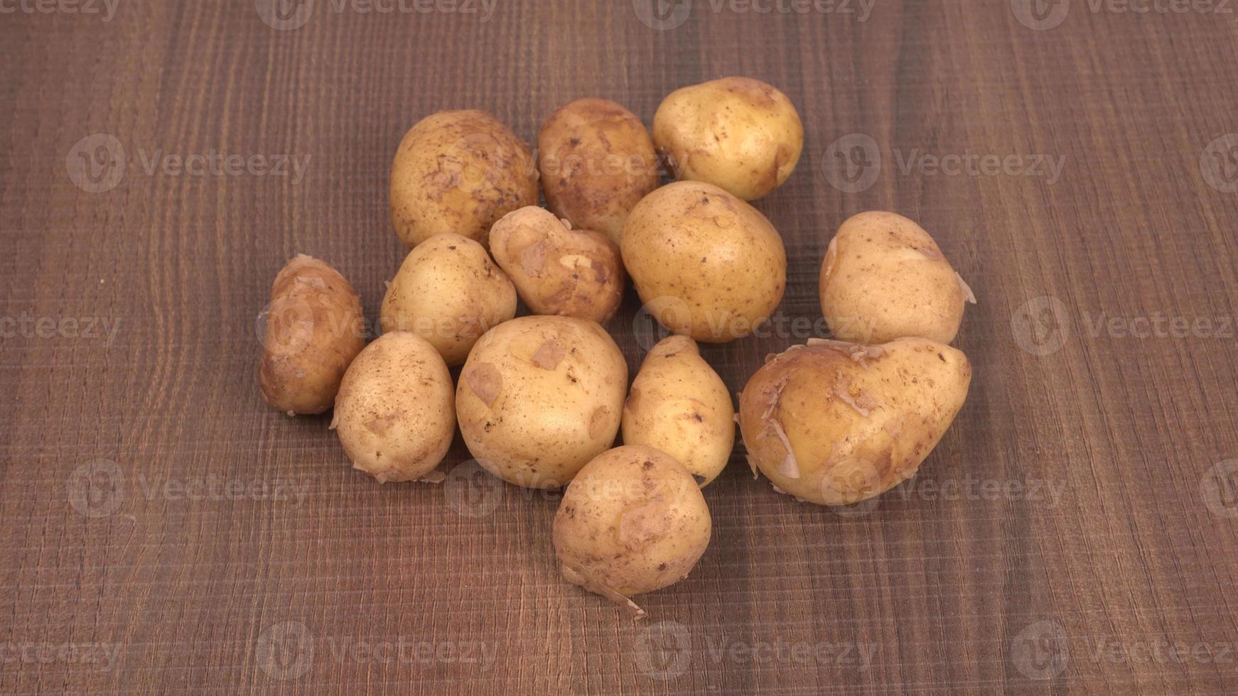 Fresh small potatoes for cooking in a wooden bowl. With copy space  on white background. photo