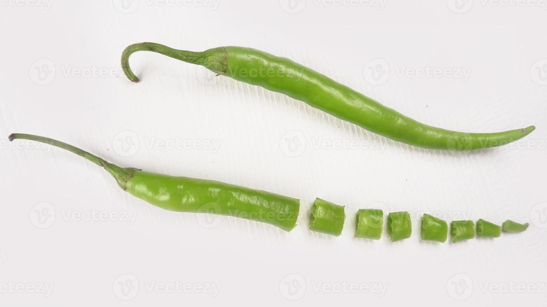 Fresh long Indian green chillies on wooden background. photo