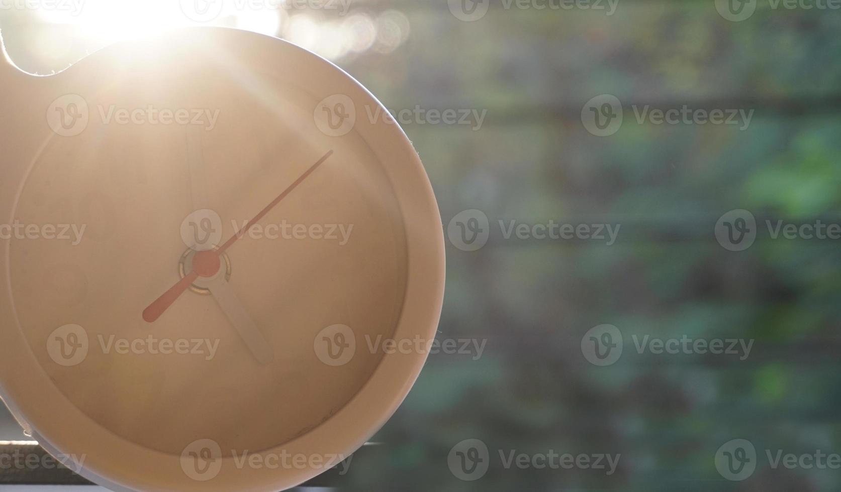 A closeup shot of a white clock with arrows showing time. photo