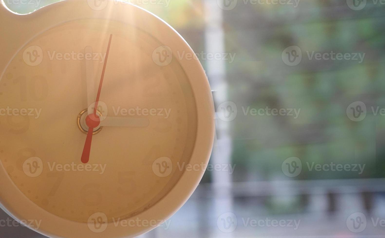 A closeup shot of a white clock with arrows showing time. photo