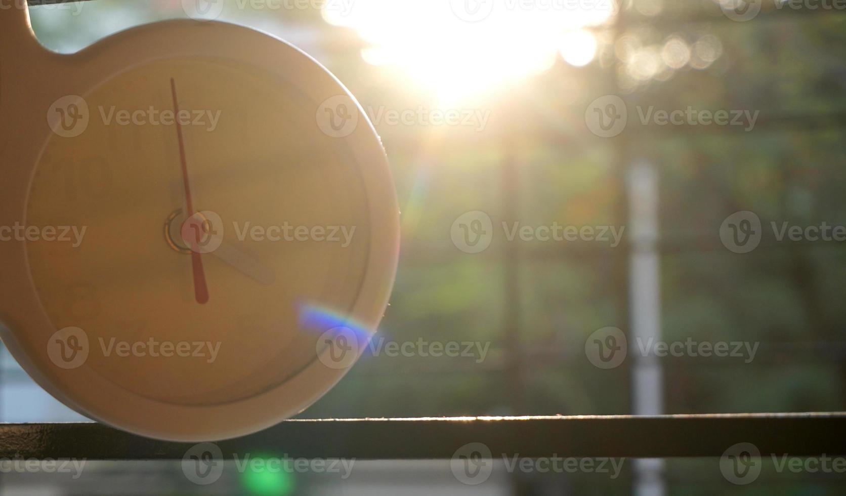 A closeup shot of a white clock with arrows showing time. photo