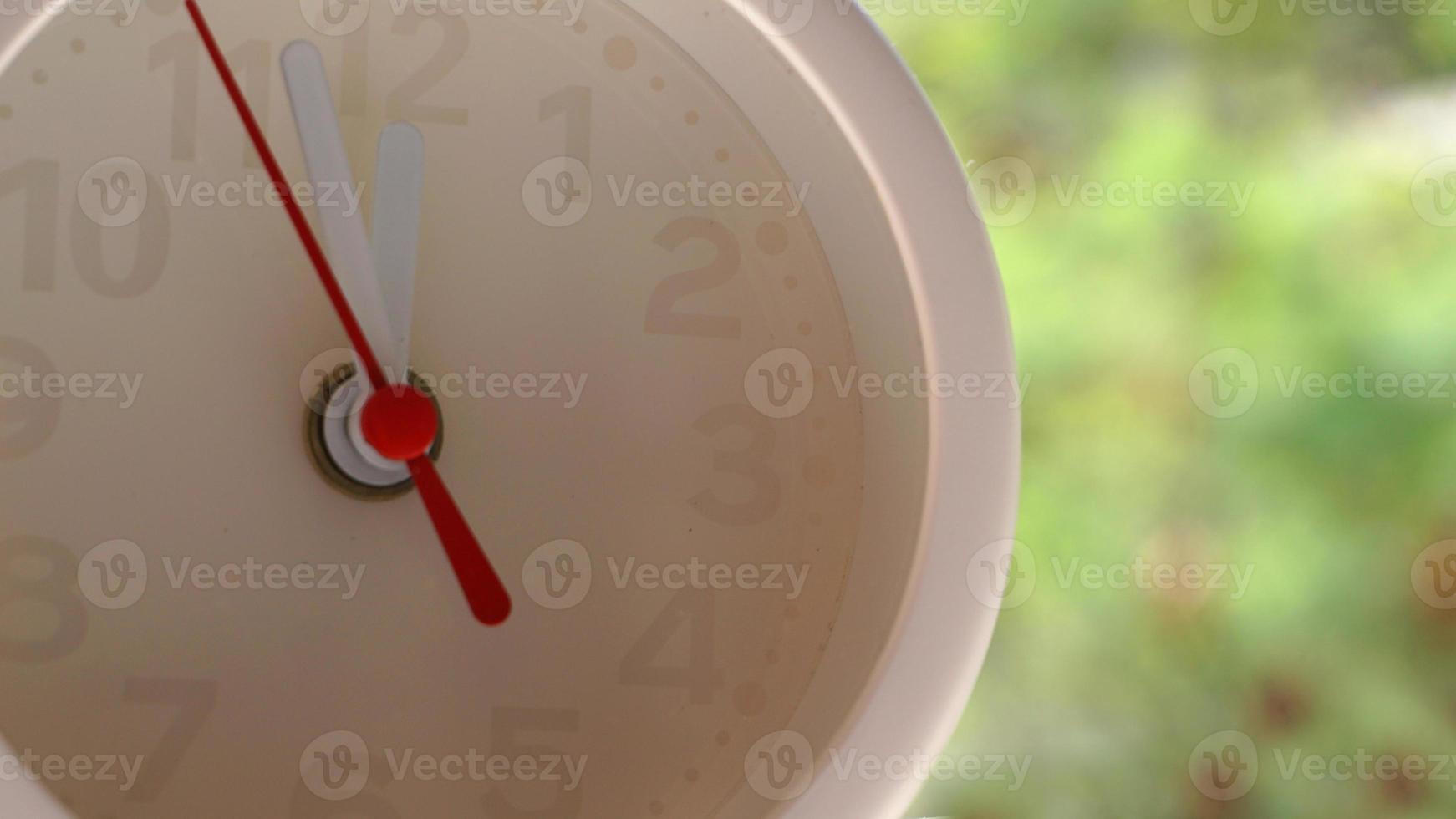 A closeup shot of a white clock with arrows showing time. photo