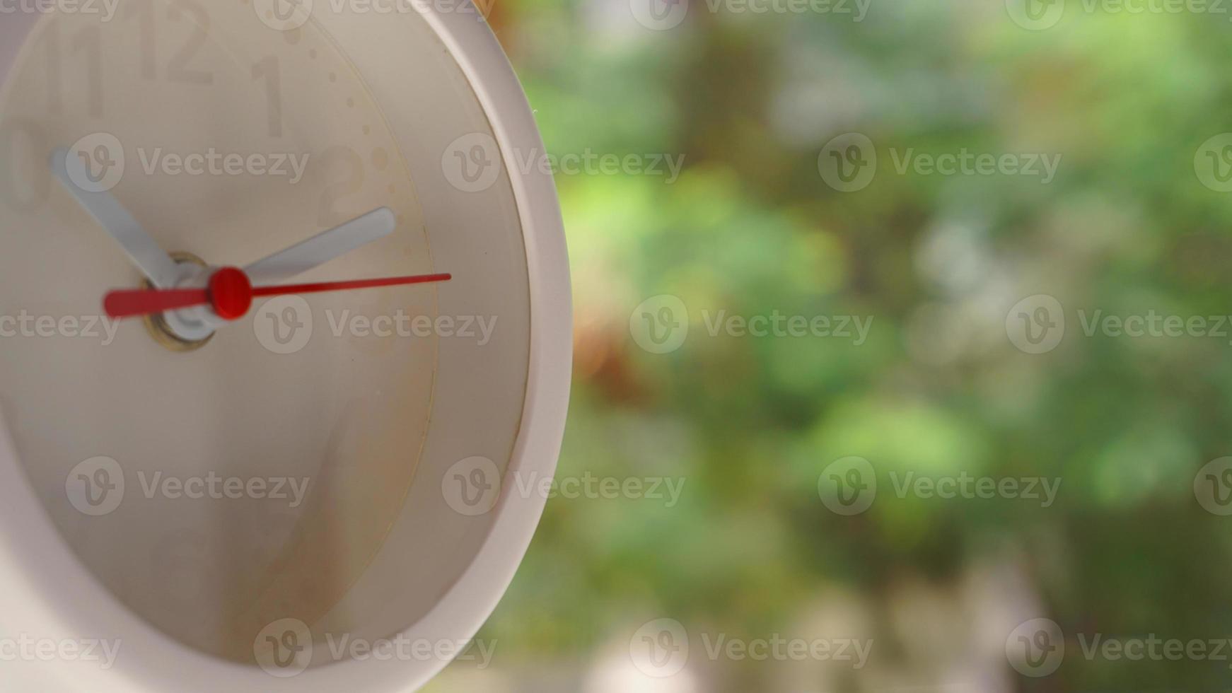 A closeup shot of a white clock with arrows showing time. photo