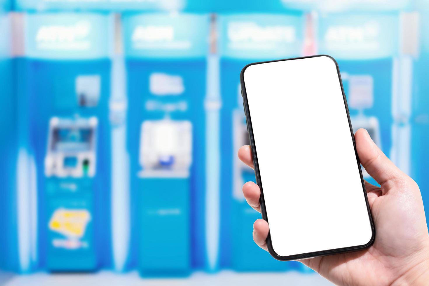 Primer plano de uso femenino mano sujetando smartphone imágenes borrosas toque de desenfoque abstracto en borrosa de cajero automático azul en grandes almacenes. para uso en segundo plano. foto