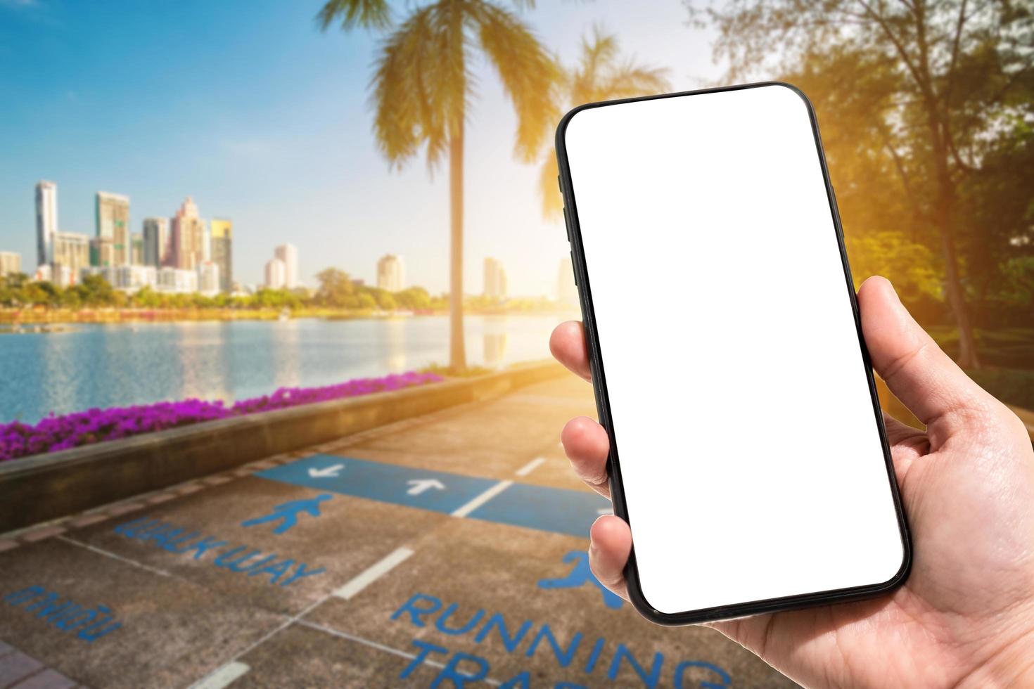 Close-up of female use smartphone blurred images in road pathway in the park for relaxing walking jogging or ride bicycle and exercise at Cityscape blur of the background. photo