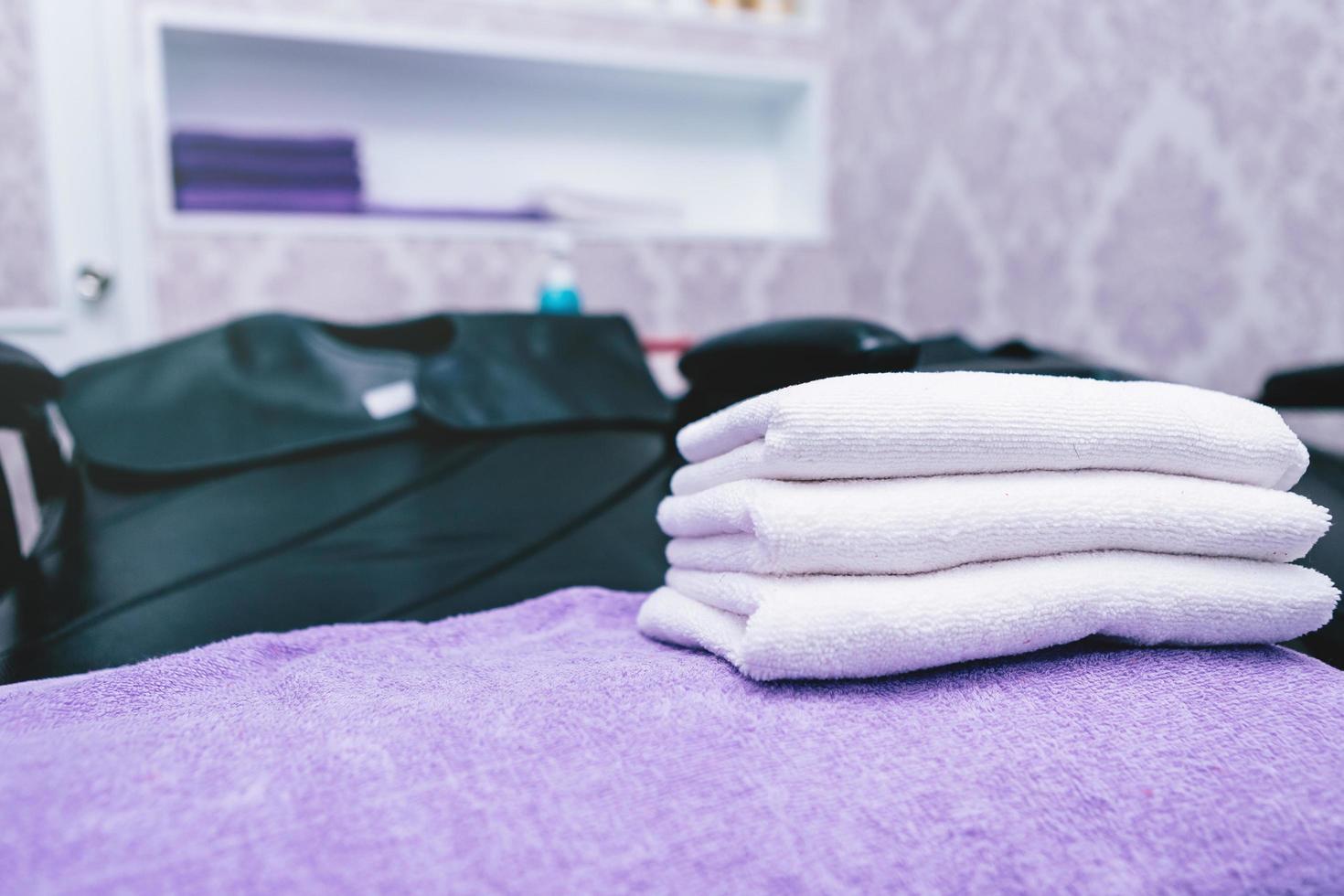 Turquoise spa towels pile on armchairs with washing stands in hairdressing salon. photo