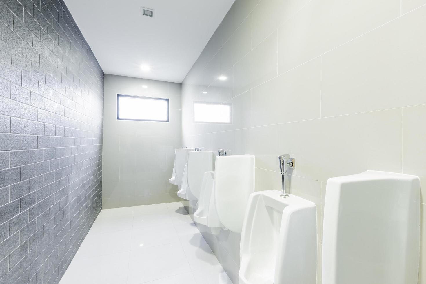 public toilet urinals lined up, no privacy. photo