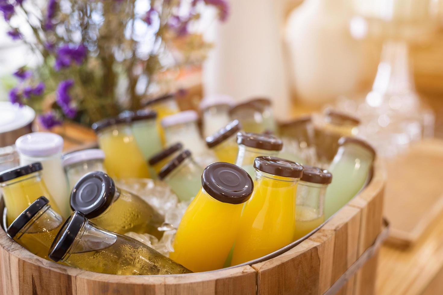 línea de desayuno buffet orgánico crudo puesto en jugo botella de bebida listo para beber prensado en frío la decoración de la mesa del comedor en el buffet autoservicio en el hotel jugo de naranja, jugo de piña, jugo de guayaba foto