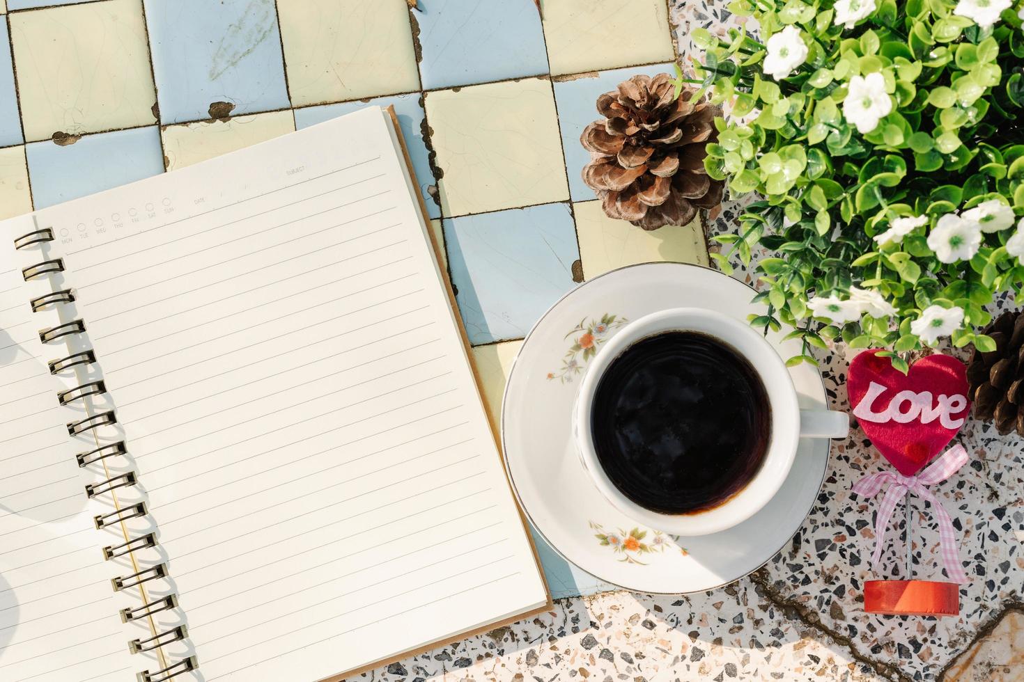 Top view image of empty notebook,spectacles and cup of coffee on Marble floor background. Love concept with heart desktop,Valentine's Day. photo