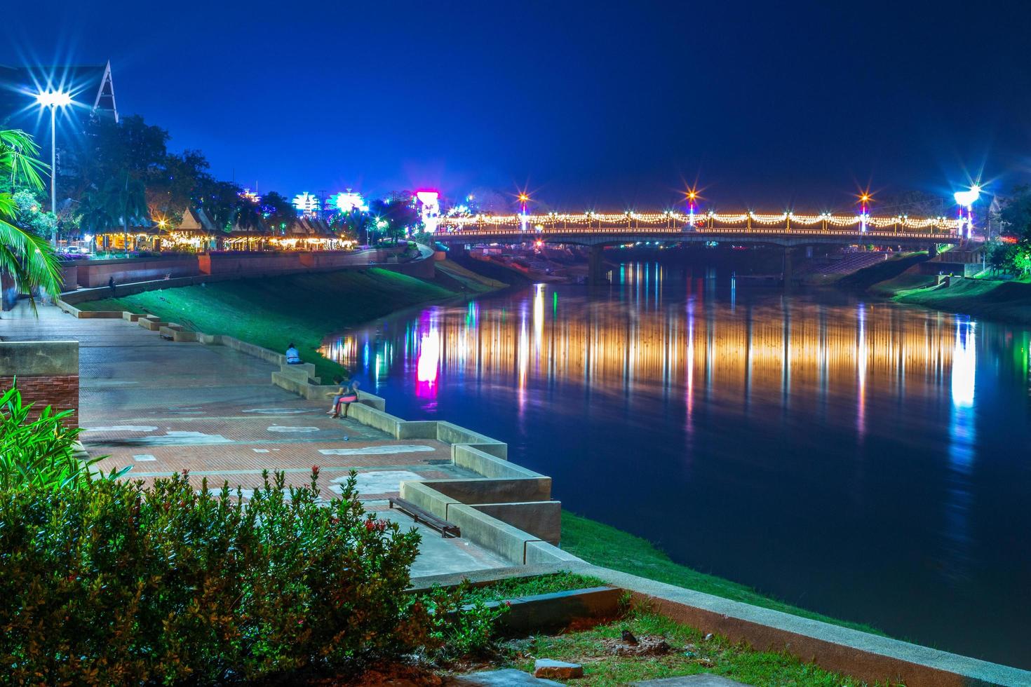 el hermoso color de las luces en el camino de la carretera en el parque para relajarse, caminar, trotar o andar en bicicleta y hacer ejercicio por la noche en la ciudad de phitsanulok, tailandia. foto