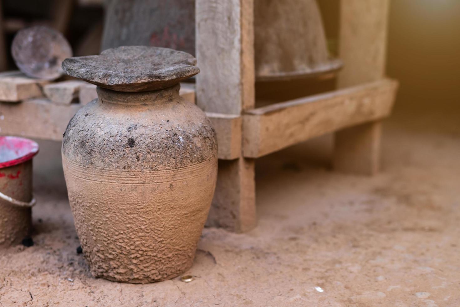 Thai old clay jars collect used charcoal with wooden table are thai traditional kitchen style. photo