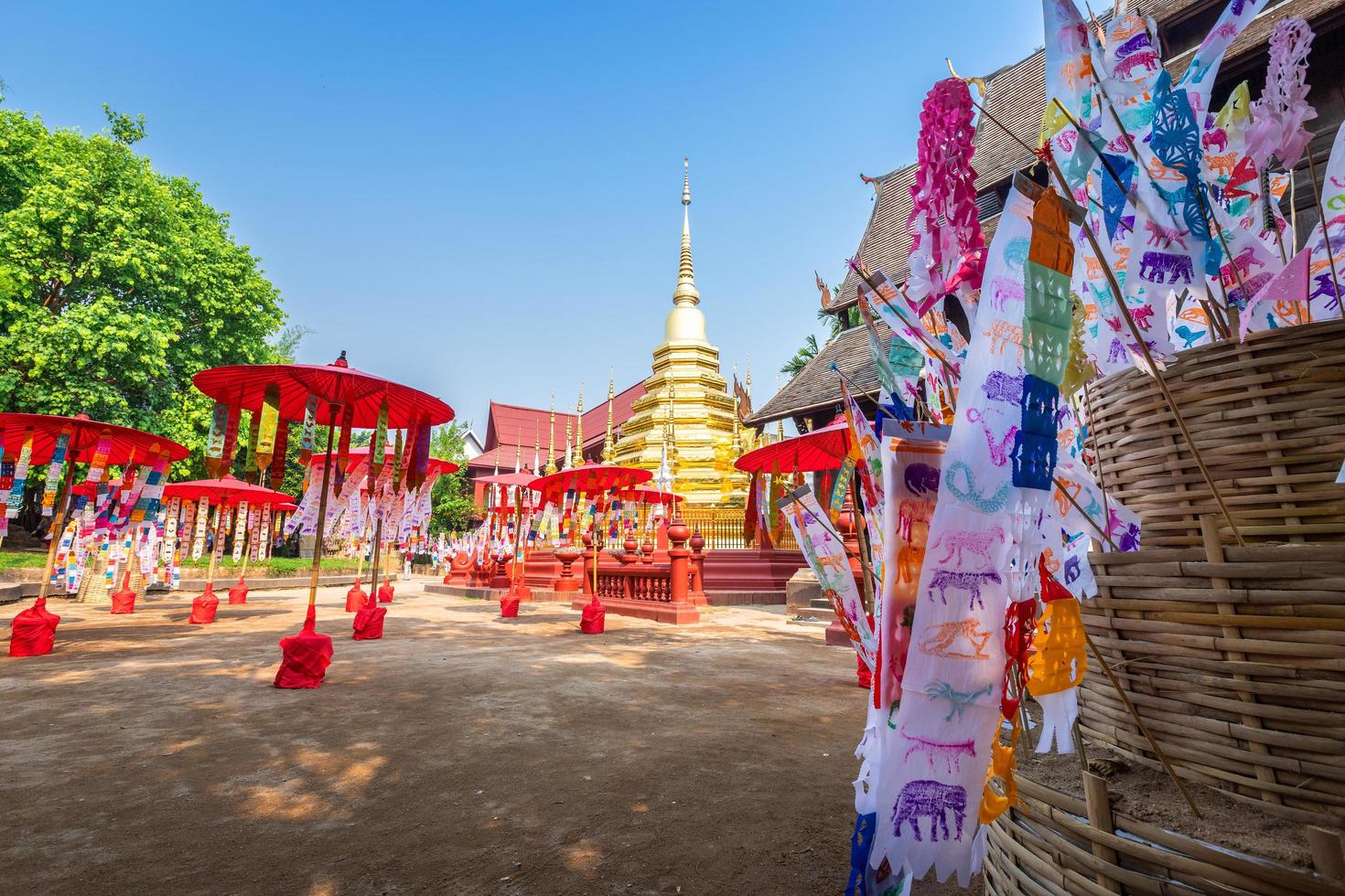 banderas de oración tung cuelgan con paraguas o bandera tradicional del norte cuelgan en la pagoda de arena en el templo phan tao para el festival de songkran se celebra en un día tradicional de año nuevo en chiang mai, tailandia foto