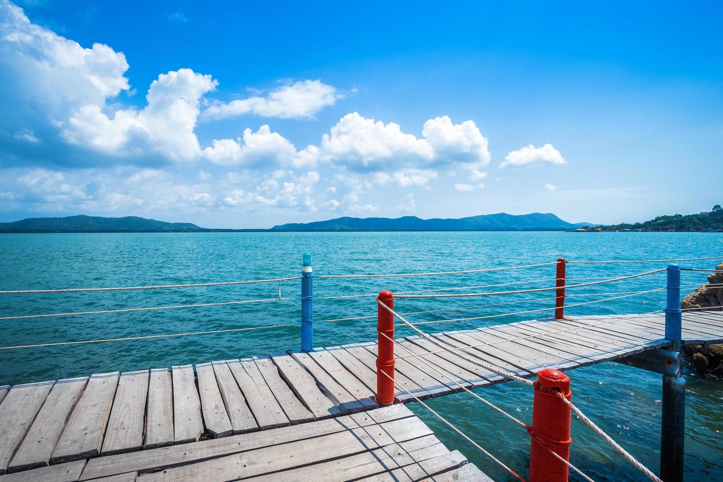 bridge wooden walking way in the sea at Hat chao lao beach blue sky background in Chanthaburi, Thailand. photo