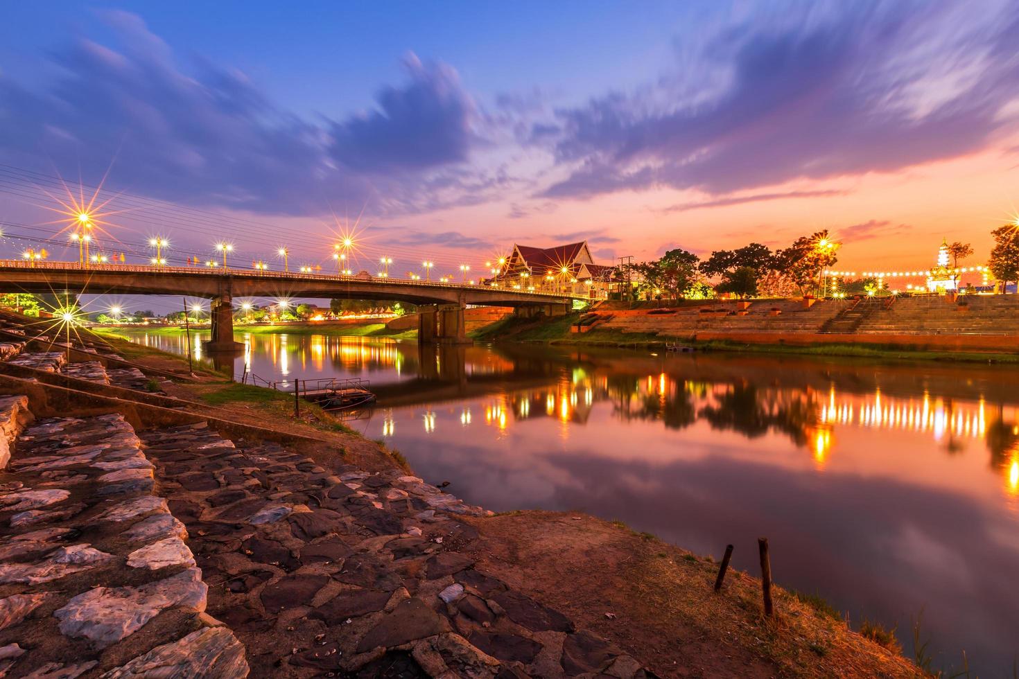 noche natural en la vista del río nan y el puente naresuan en el parque para relajarse, caminar, trotar y hacer ejercicio al atardecer en la ciudad de phitsanulok, tailandia. foto