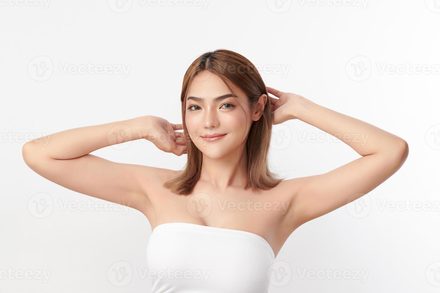 Beautiful Young Asian woman lifting hands up to show off clean and hygienic armpits or underarms on white background, Smooth armpit cleanliness and protection concept photo