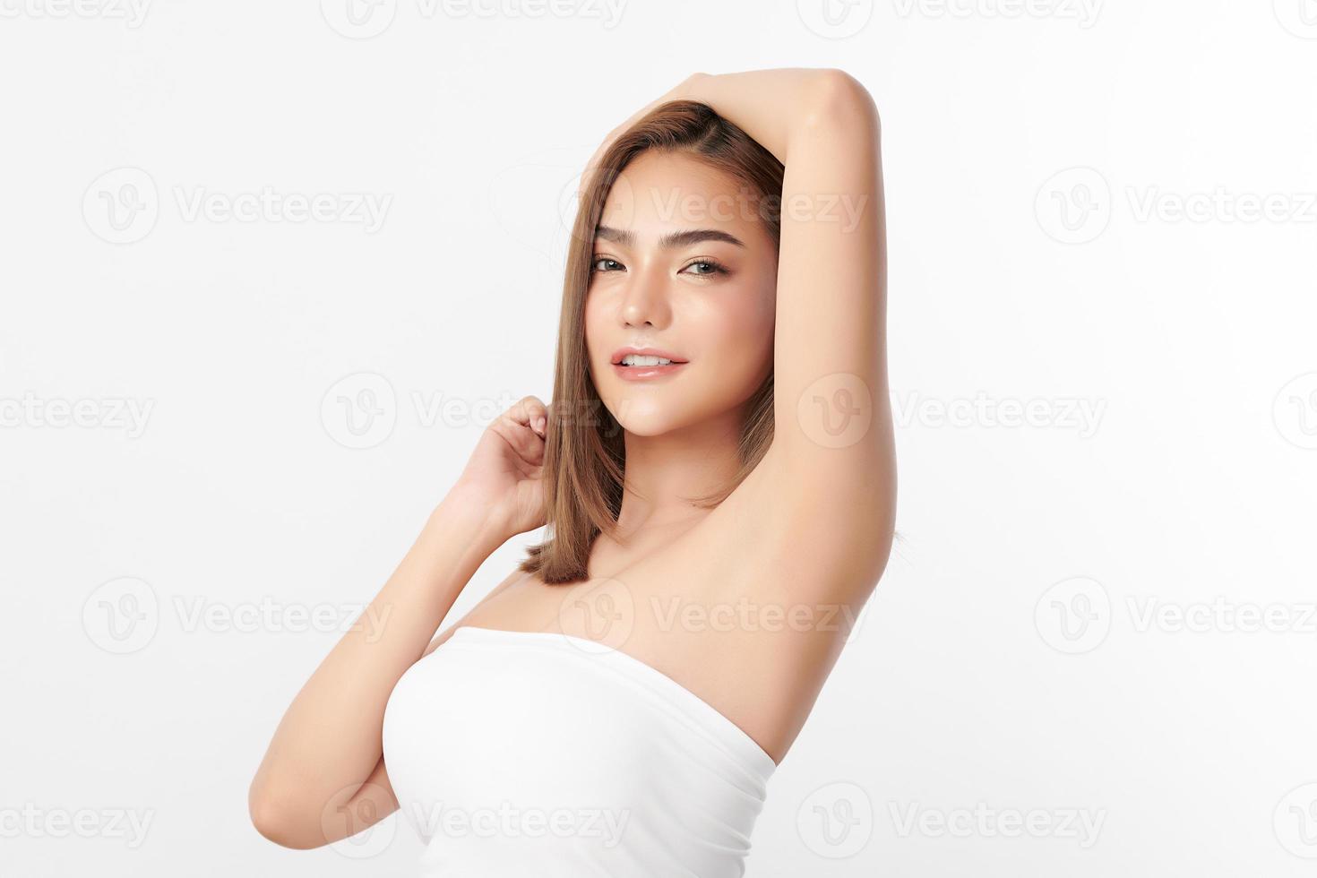 Beautiful Young Asian woman lifting hands up to show off clean and hygienic armpits or underarms on white background, Smooth armpit cleanliness and protection concept photo