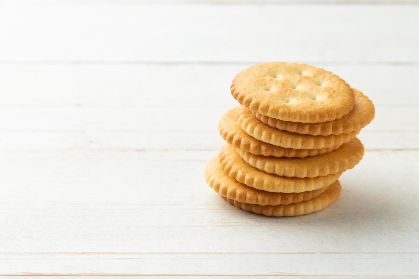 Rounded Cracker cookies on white wooden table background photo