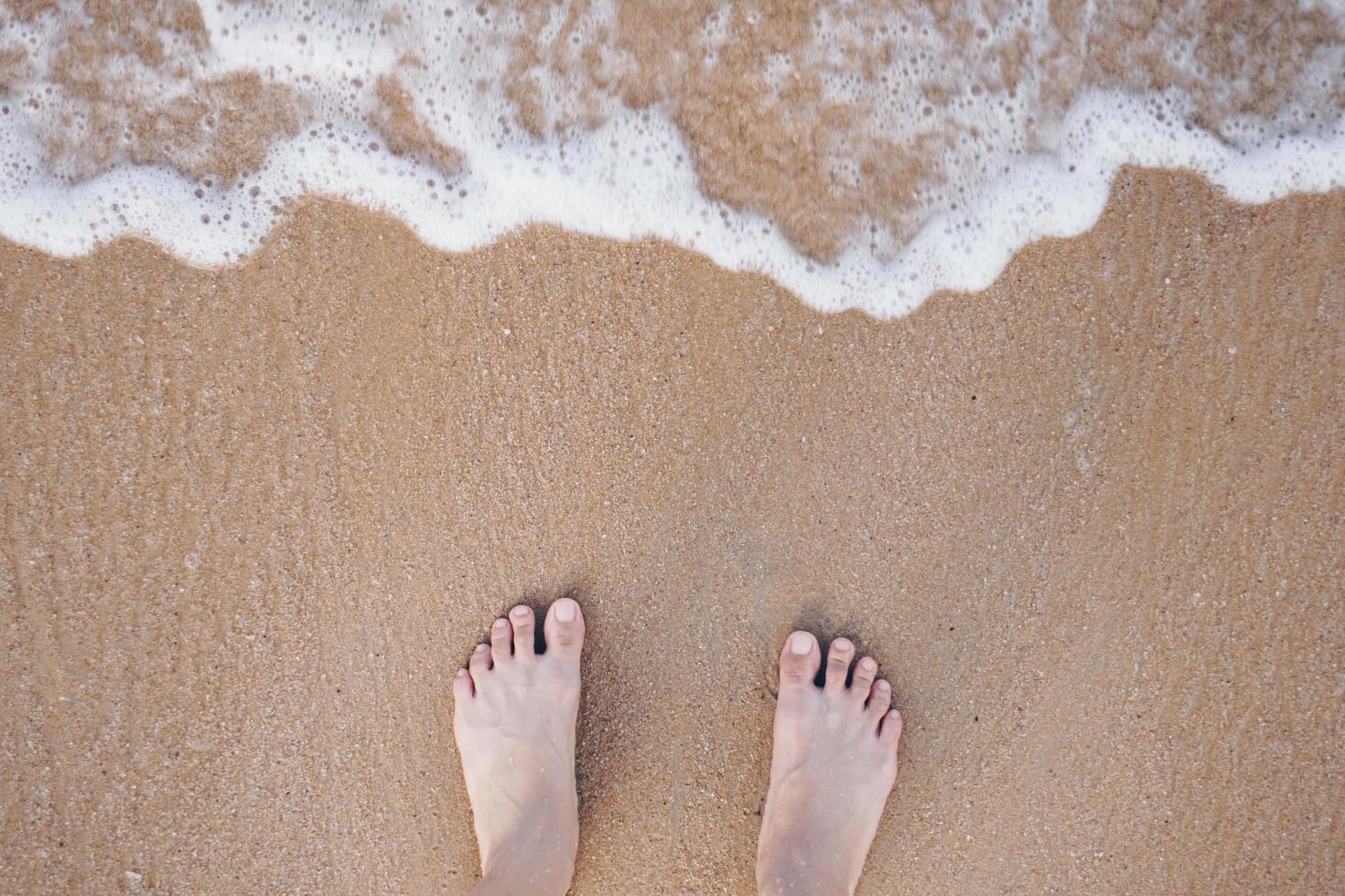 Summer vacation concept barefoot on sand at beach with copyspace. photo