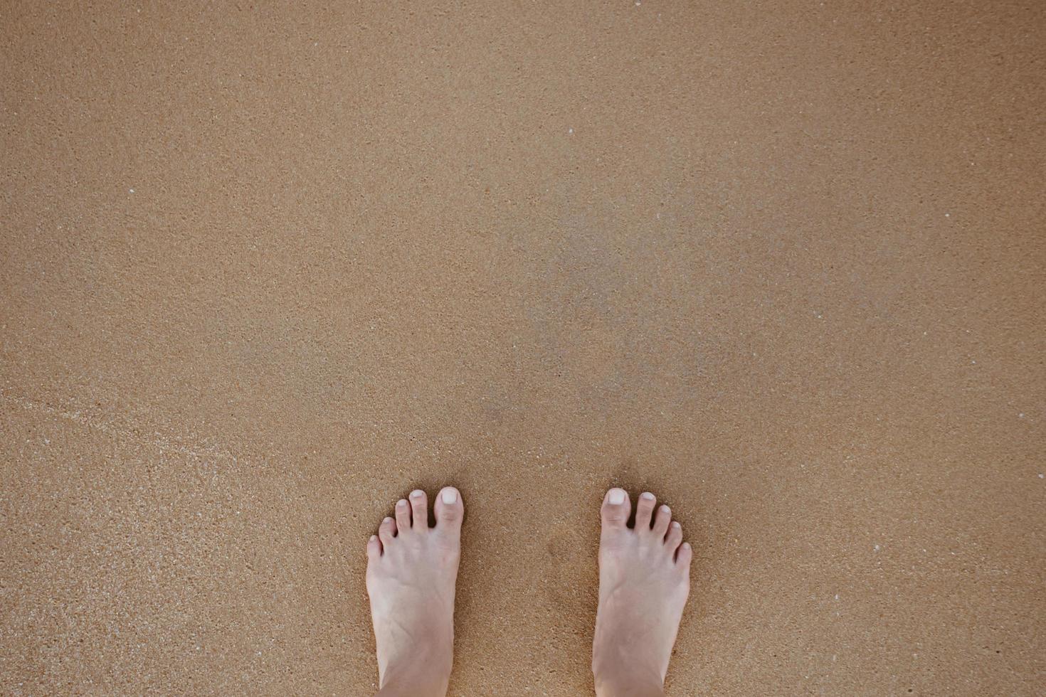 Summer vacation concept barefoot on sand at beach with copyspace. photo