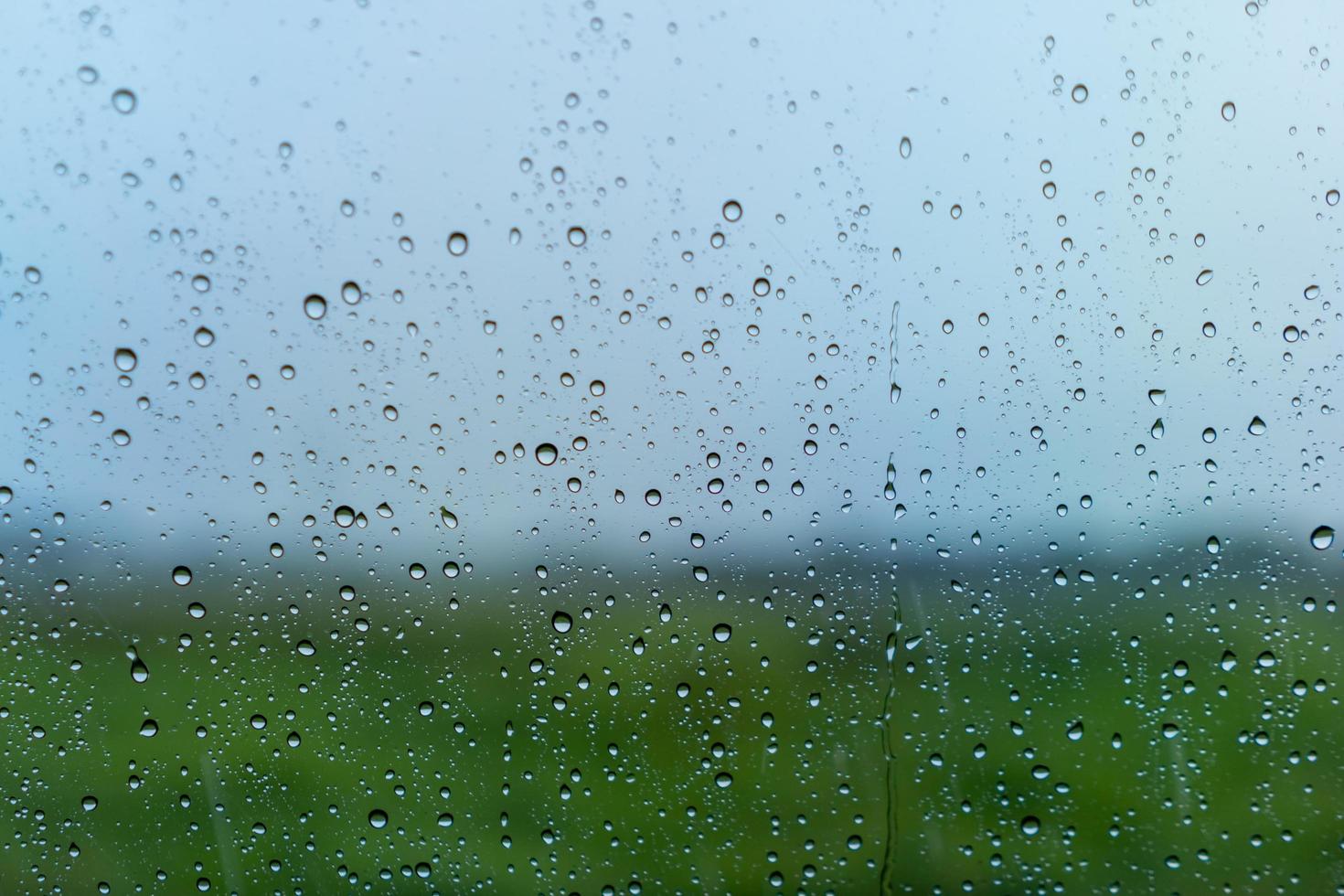 It's raining outside and a raindrop falls on the glass window. photo