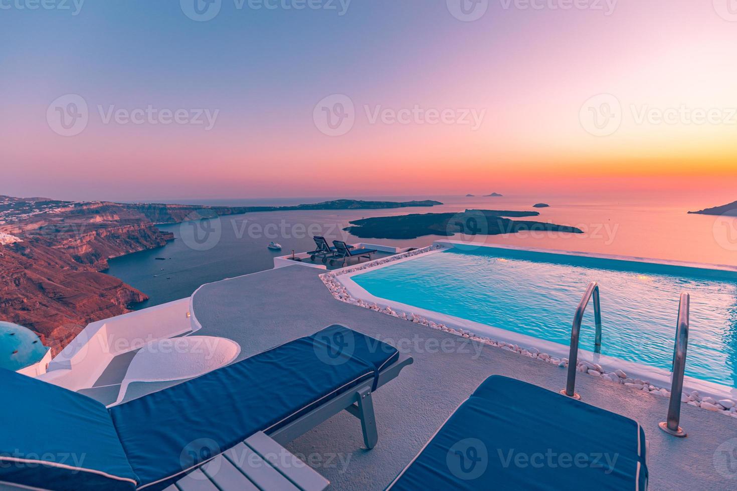 Infinity pool on the rooftop at sunset in Santorini Island, Greece. Beautiful poolside and sunset sky. Luxurious summer vacation and holiday concept, romantic scenery and evening view photo