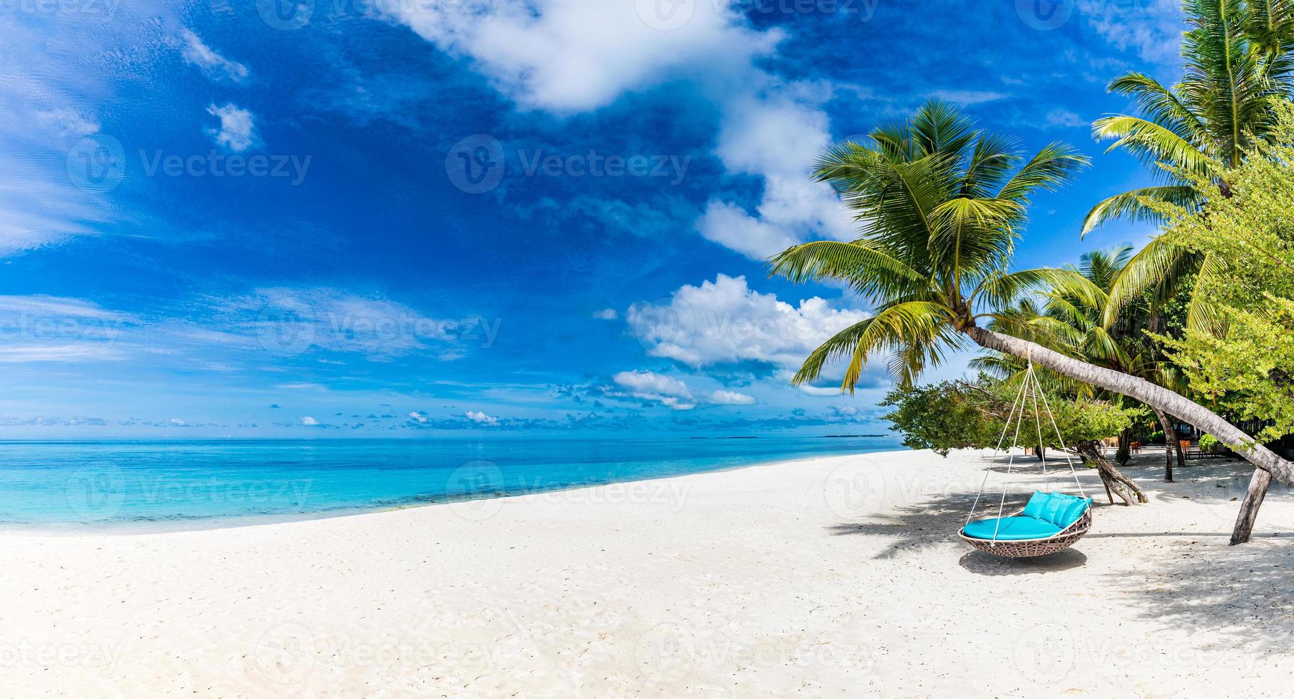 Tropical beach background as summer relax landscape with beach swing or hammock and white sand and calm sea for beach template. Amazing beach scene vacation and summer holiday concept. Luxury travel photo