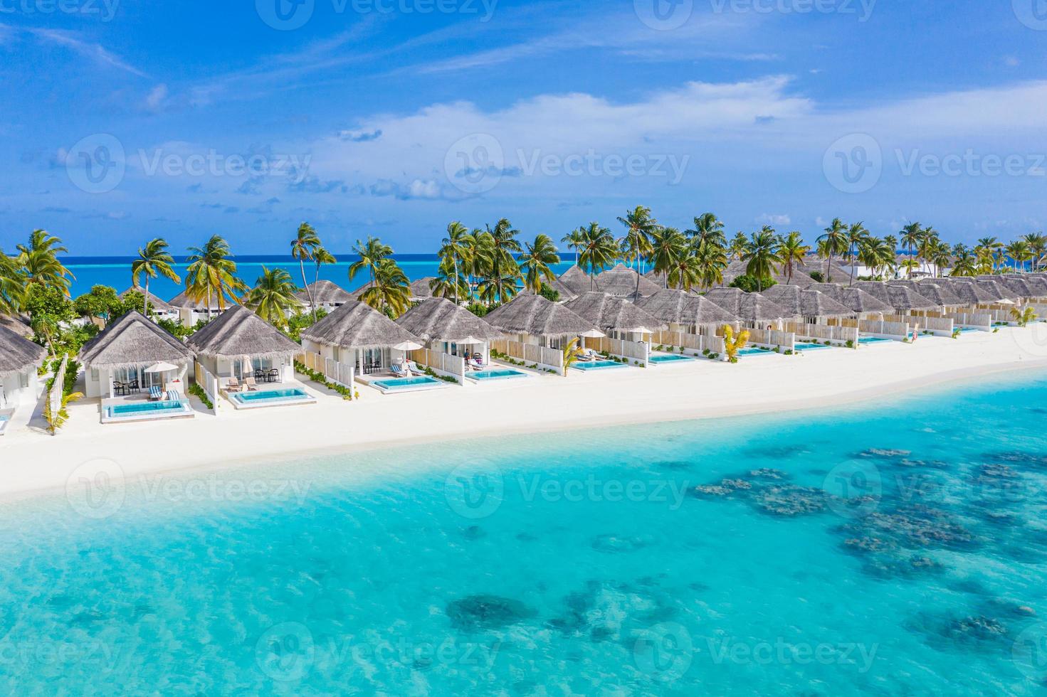 Perfect aerial landscape, luxury tropical resort or hotel with water villas and beautiful beach scenery. Amazing bird eyes view in Maldives, landscape seascape aerial view over a Maldives photo