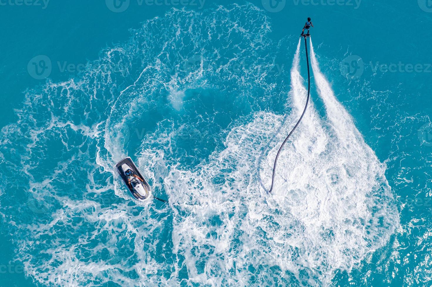 Vista aérea del deporte acuático de acción extrema, mar de verano, cerca del resort tropical de lujo. fly board en ocean lagoon, libertad de diversión como actividad recreativa de verano. vista de flyboard desde drone foto